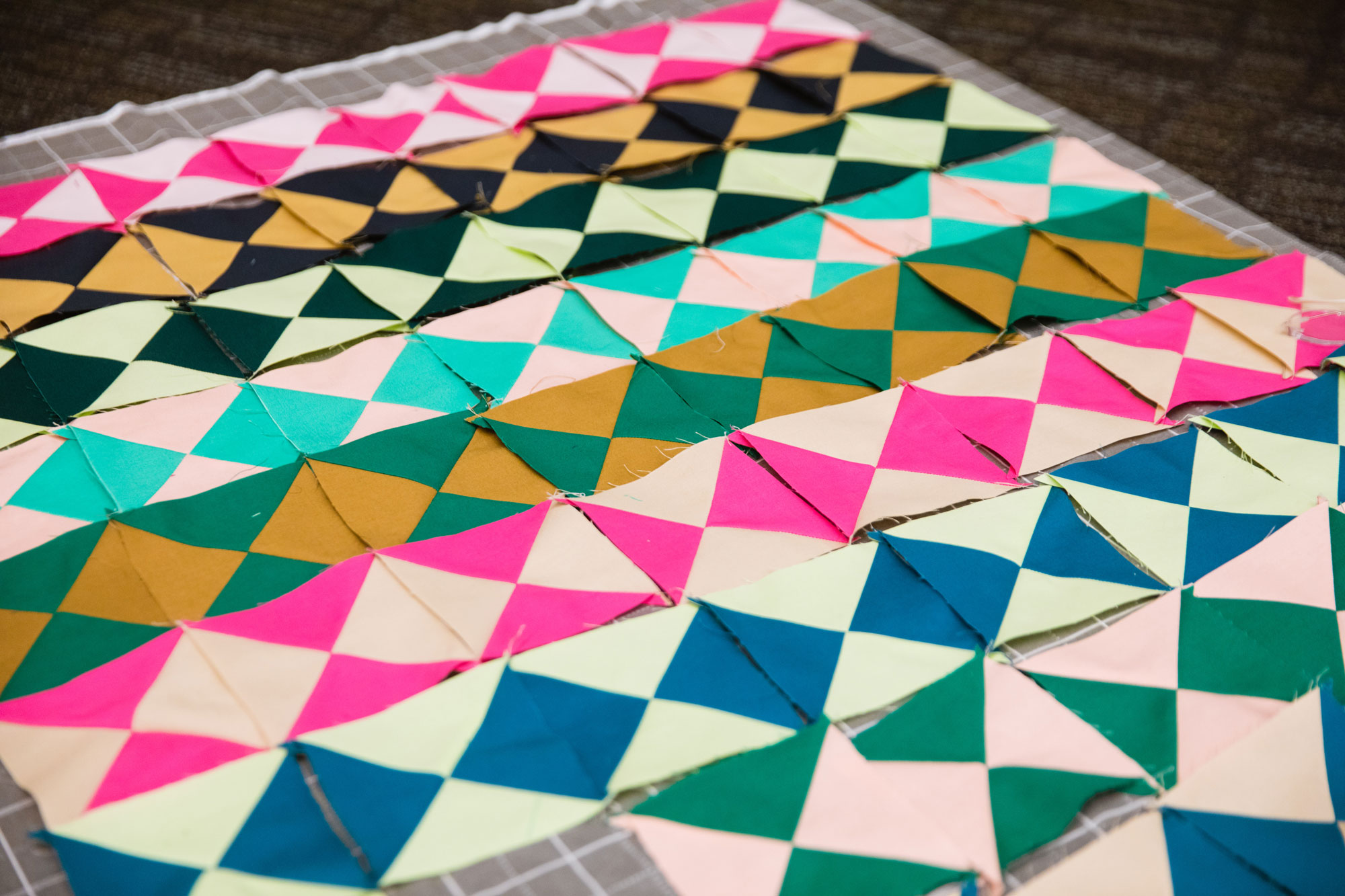 Bright colored hour-glass quilt blocks in pinks, greens, blues